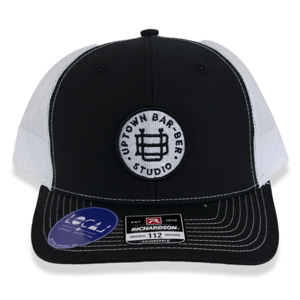 Black and white trucker hat with round logo patch